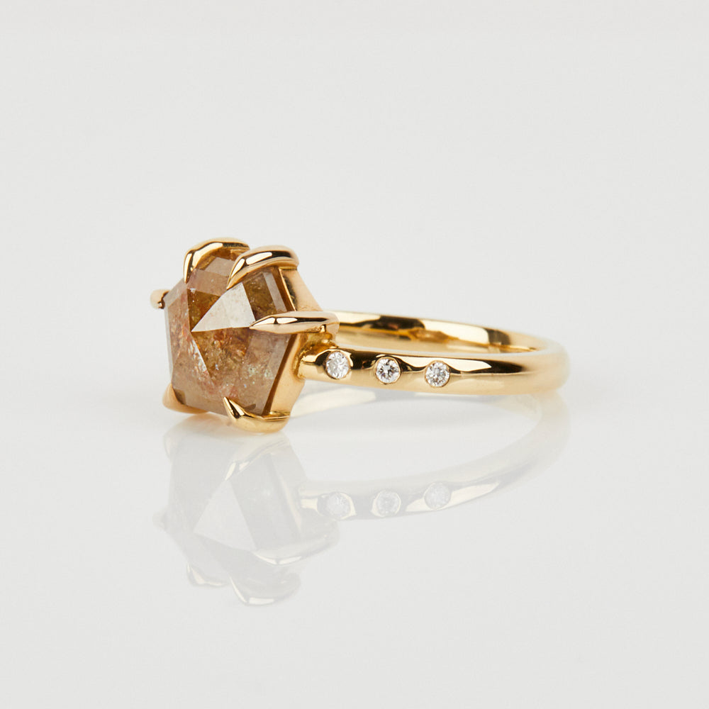 Hexagon-shaped diamond engagement ring with a gold band and round diamonds