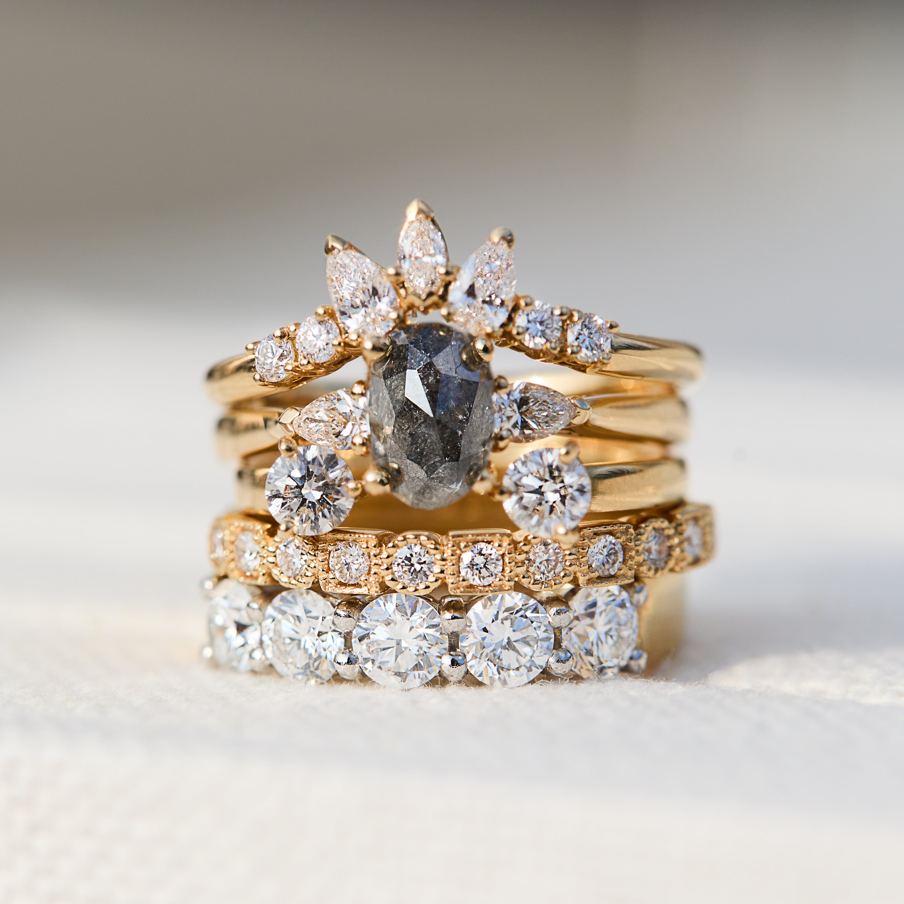 salt and pepper diamond stack featuring yellow gold engagement and wedding rings