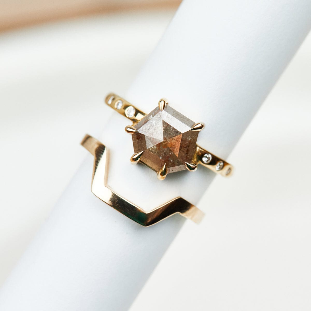Hexagon-shaped diamond engagement ring with a gold band and round diamonds
