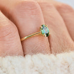 An 18ct yellow gold engagement ring with an oval green sapphire.