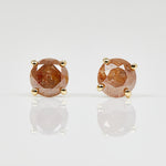 1ct round brilliant cut burnt orange diamonds set in 18ct yellow gold stud earrings.