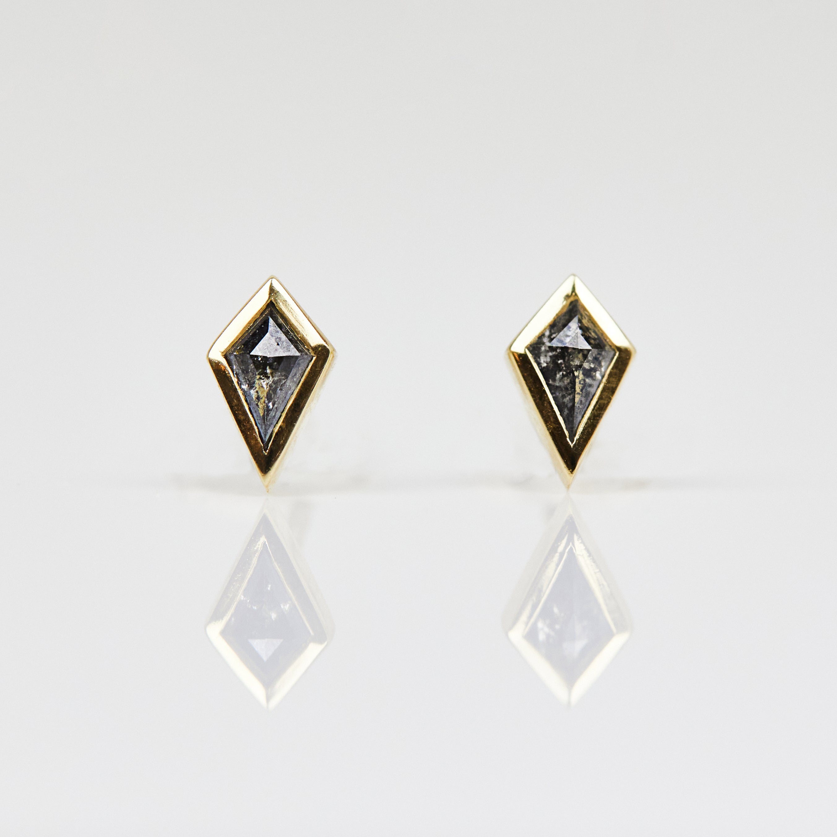 Salt and pepper kite-shaped diamond stud earrings in 18ct yellow gold.