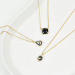Black cushion cut diamond necklace in 18ct yellow gold.