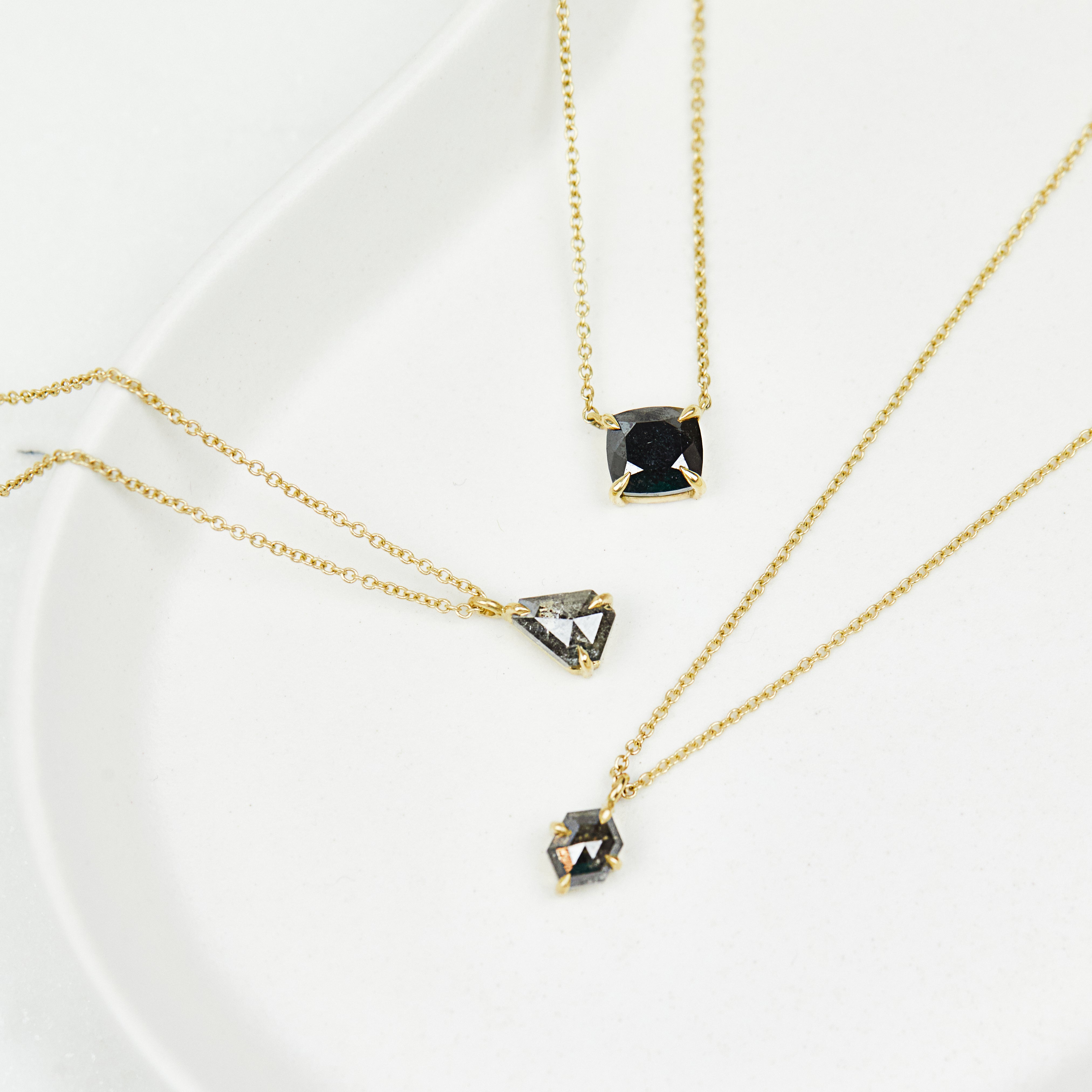 Black cushion cut diamond necklace in 18ct yellow gold.