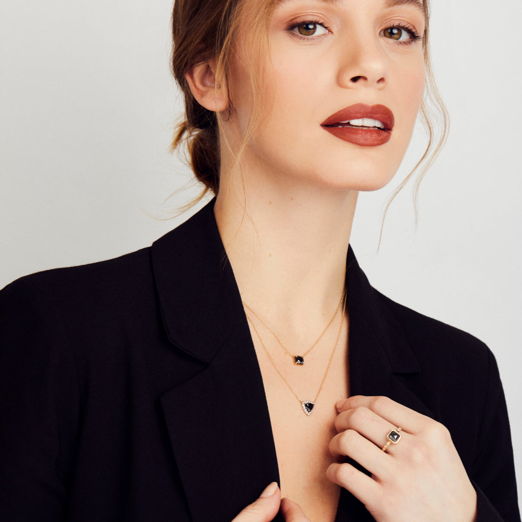 Black diamond triangle halo necklace with white diamonds in 18ct yellow gold.