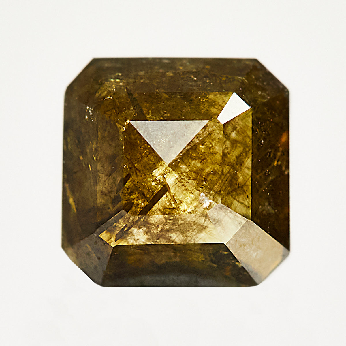 Emerald-shaped rose-cut green diamond with unique inclusions.