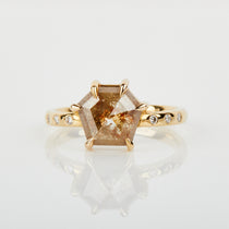 Hexagon-shaped diamond engagement ring with a gold band and round diamonds
