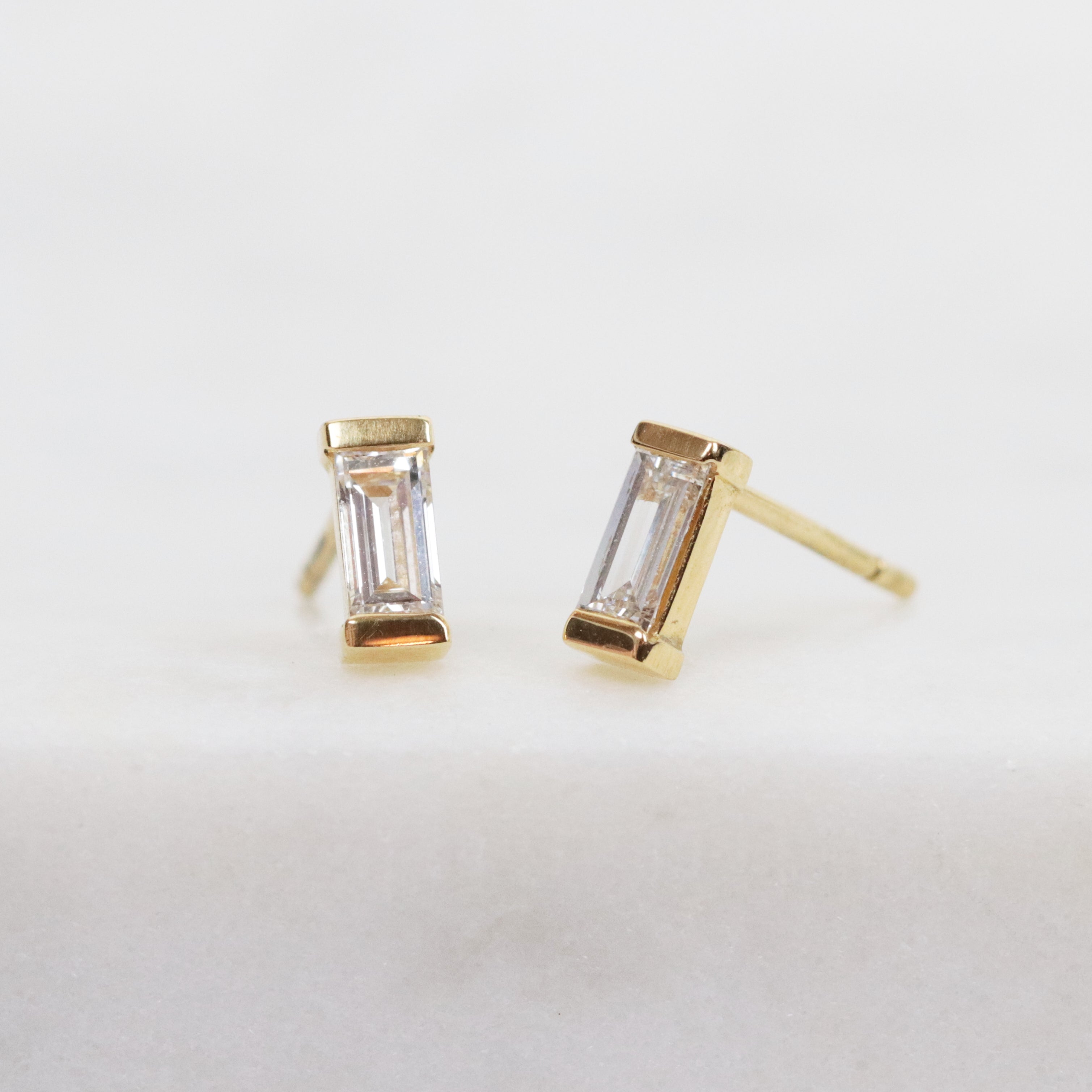 White baguette-cut lab-grown diamond earrings set in 18ct yellow gold.