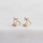 White baguette-cut lab-grown diamond earrings set in 18ct yellow gold.