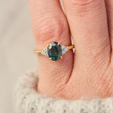australian oval teal sapphire engagement ring with round diamond side stones