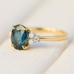 australian oval teal sapphire engagement ring with round diamond side stones