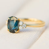 australian oval teal sapphire engagement ring with round diamond side stones