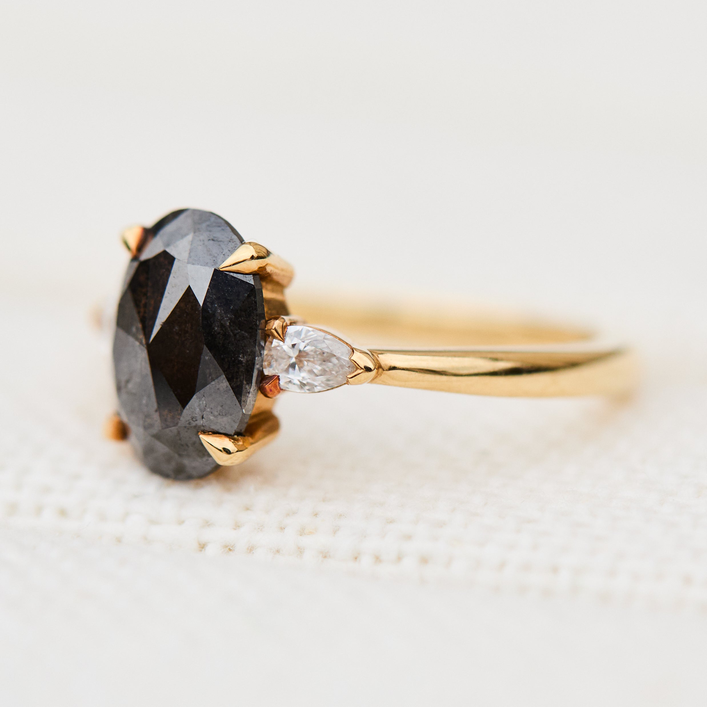 black oval salt and pepper diamond engagement ring in yellow gold
