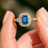 blue sapphire emerald cut engagement ring in yellow gold