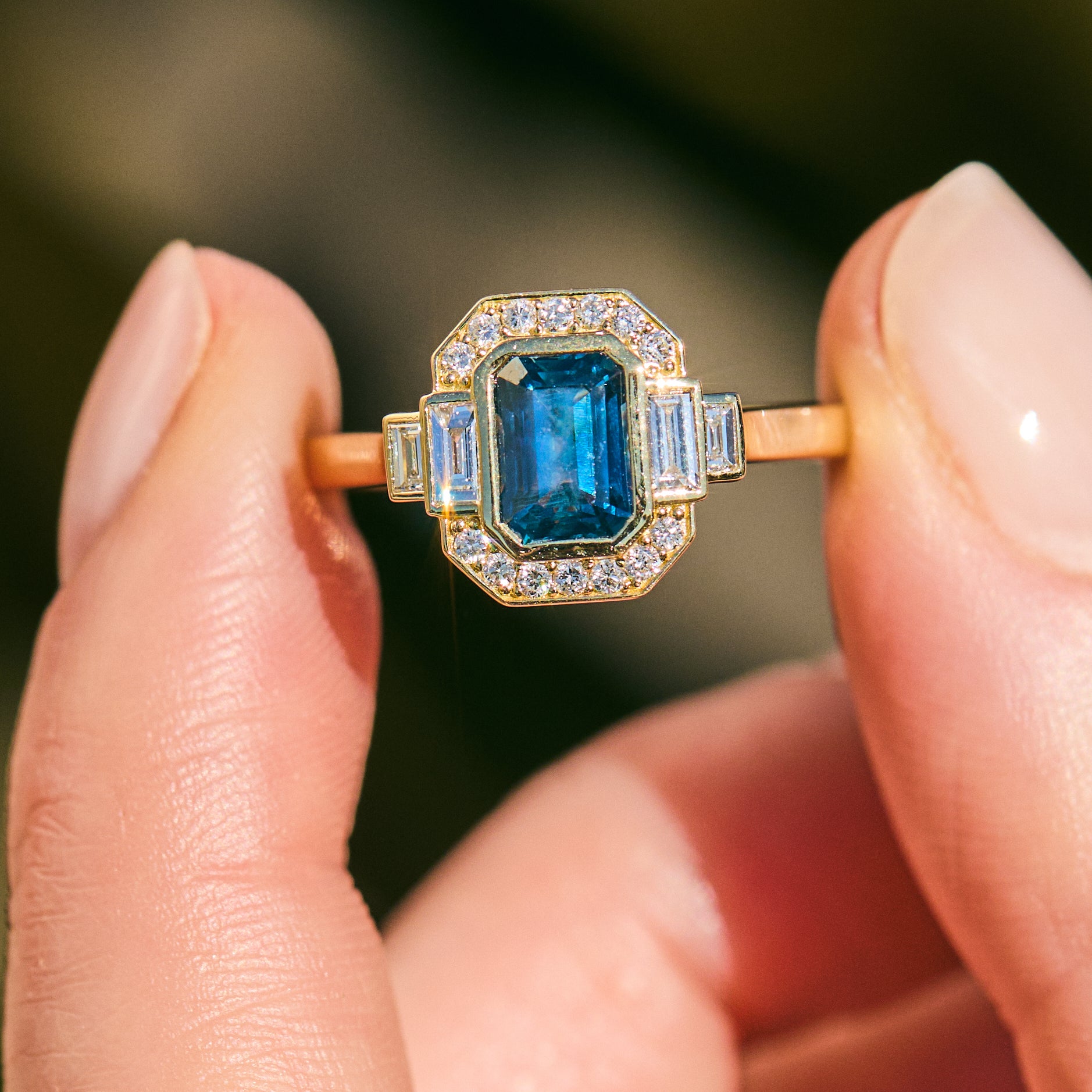 blue sapphire emerald cut engagement ring in yellow gold