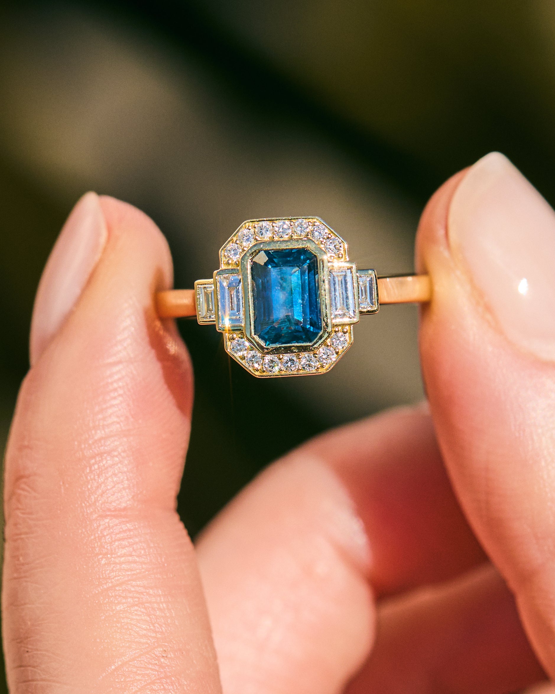 blue sapphire emerald cut engagement ring in yellow gold