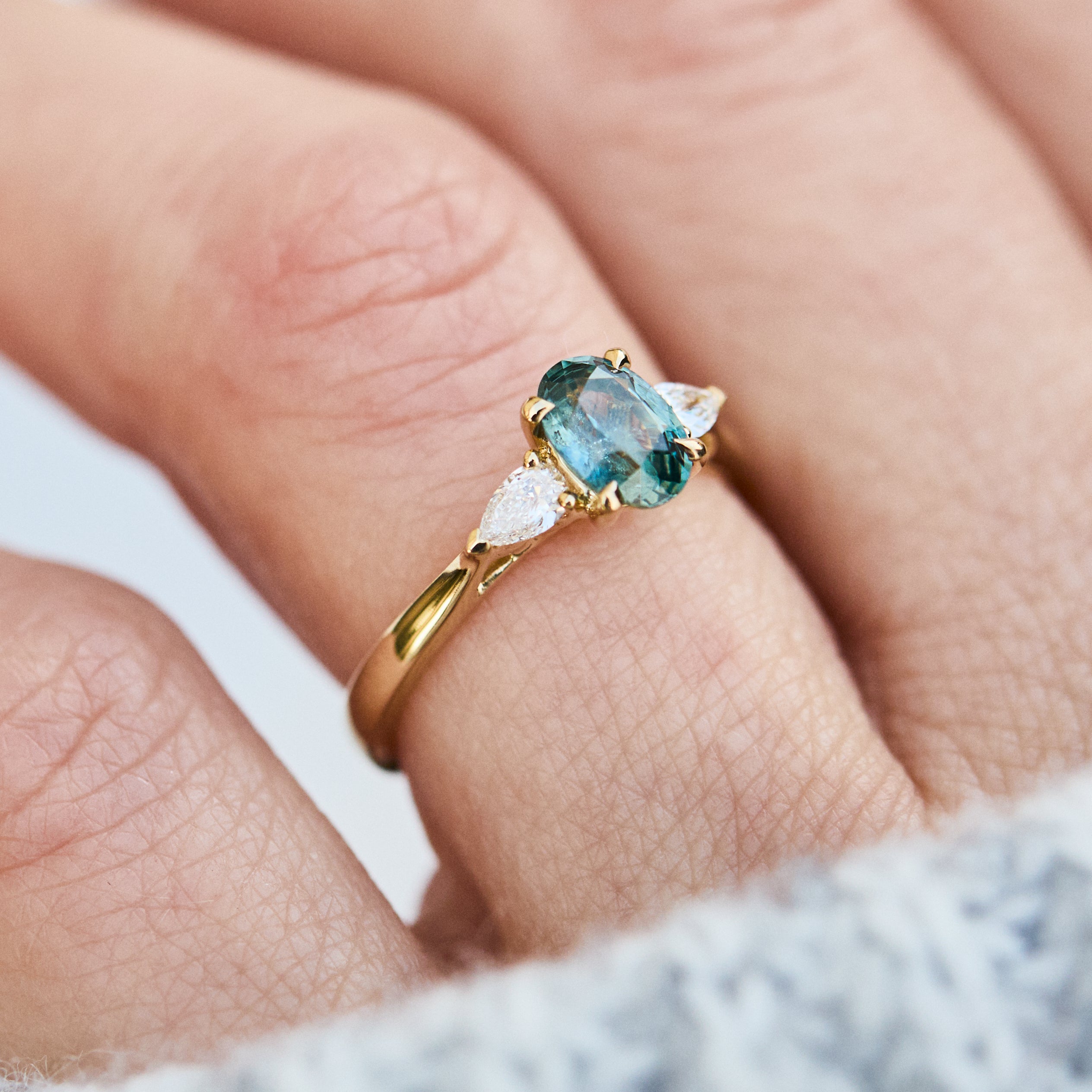 oval blue teal montana sapphire engagement ring in yellow gold