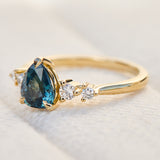 pear shape blue teal sapphire engagement ring set in yellow gold