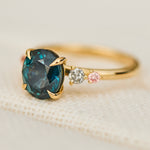 oval blue teal sapphire yellow gold engagement ring with four side stones