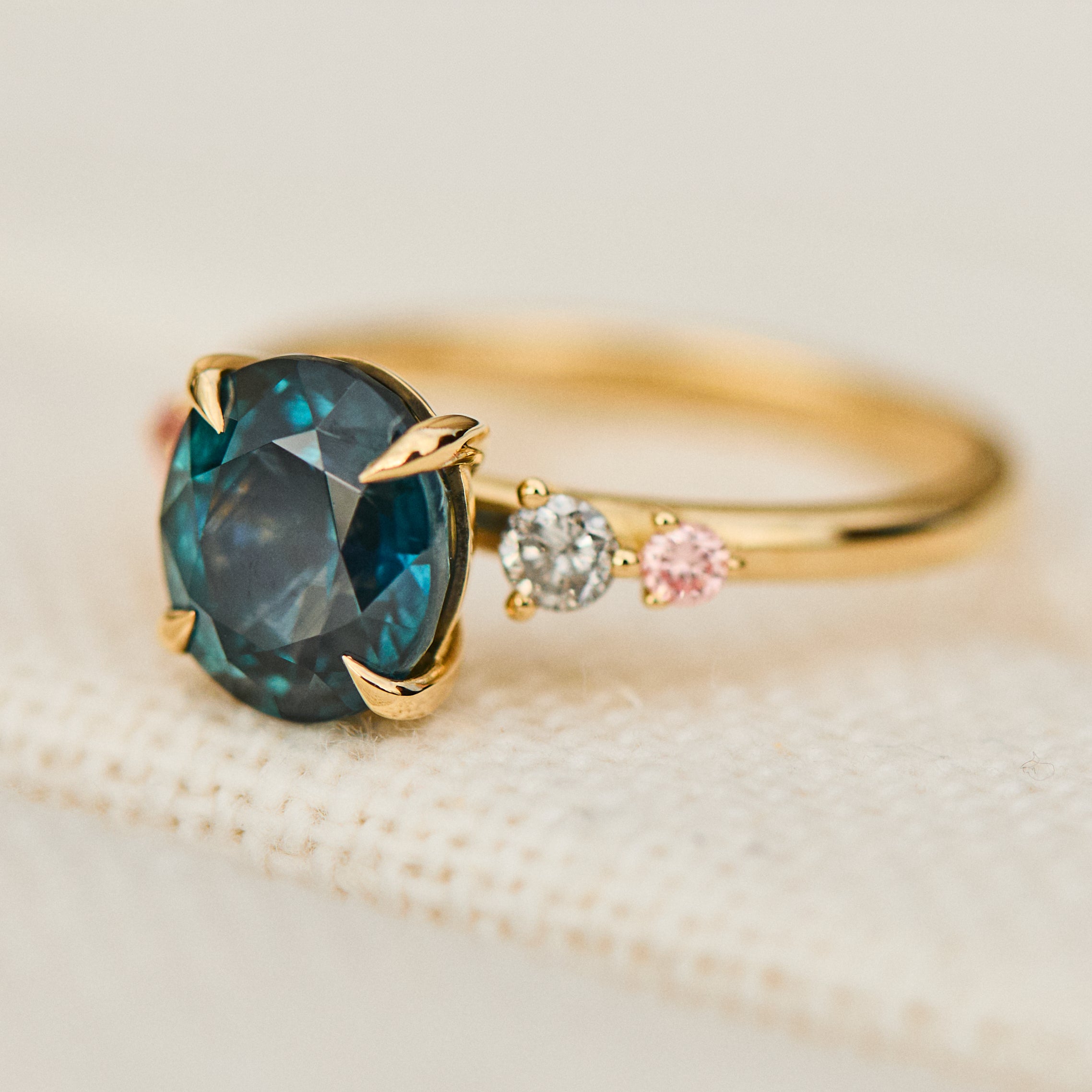 oval blue teal sapphire yellow gold engagement ring with four side stones