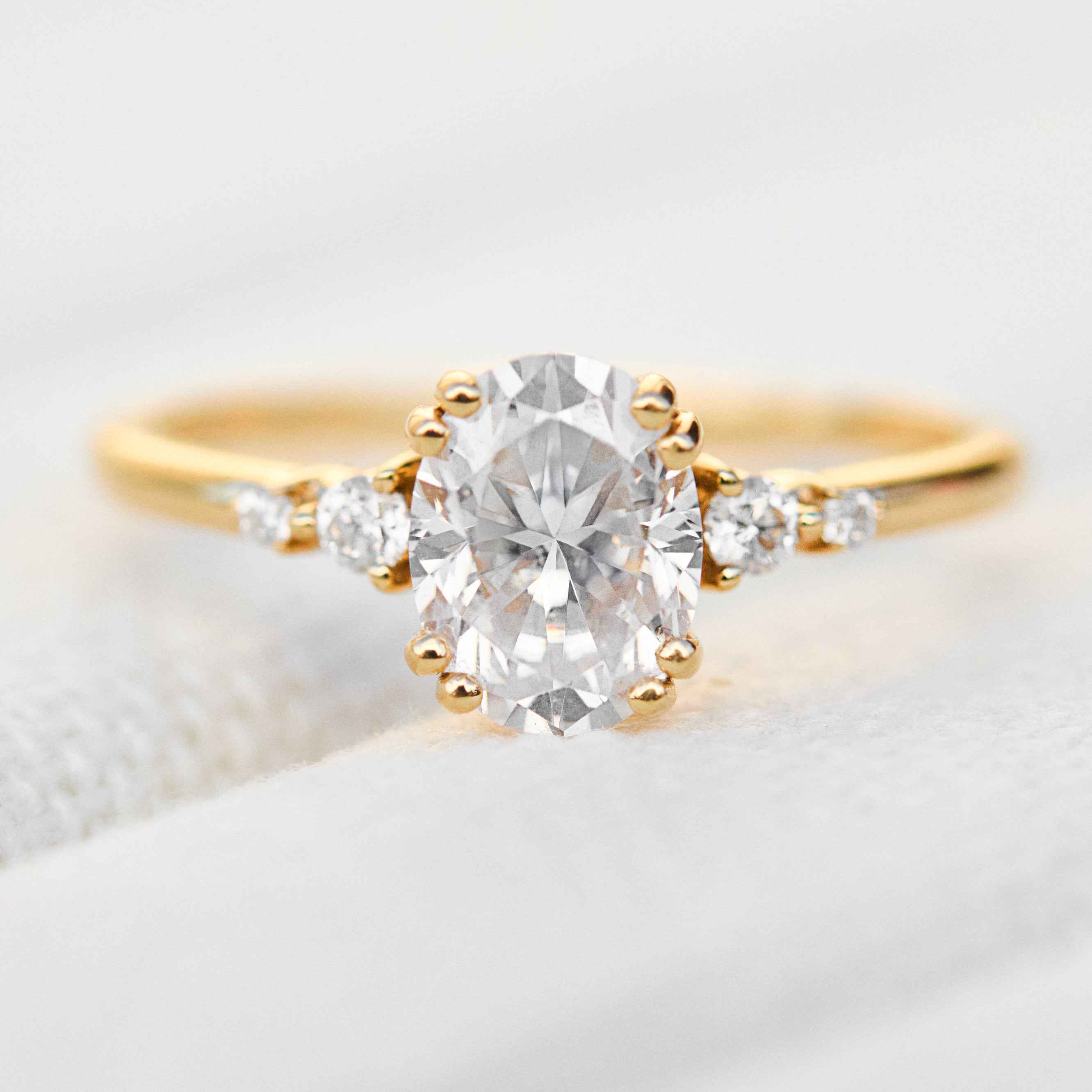 cushion cut moissanite and diamond engagement ring in yellow gold