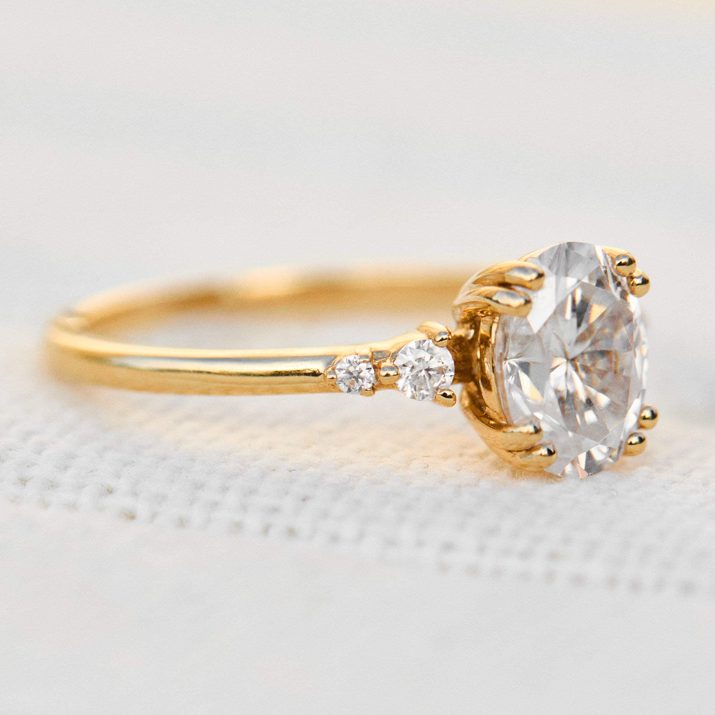 cushion cut moissanite and diamond engagement ring in yellow gold