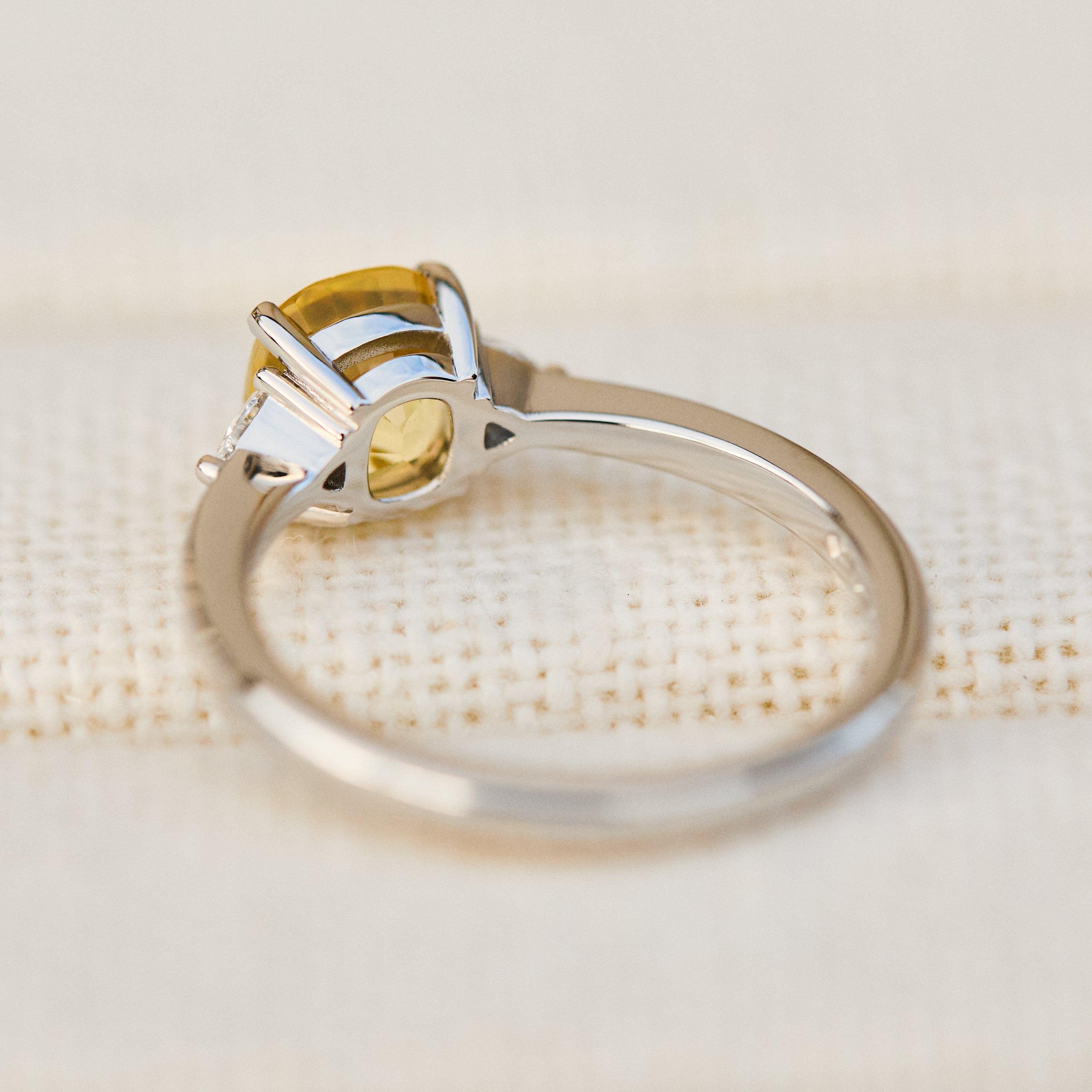 cushion cut yellow sapphire trilogy engagement ring in platinum