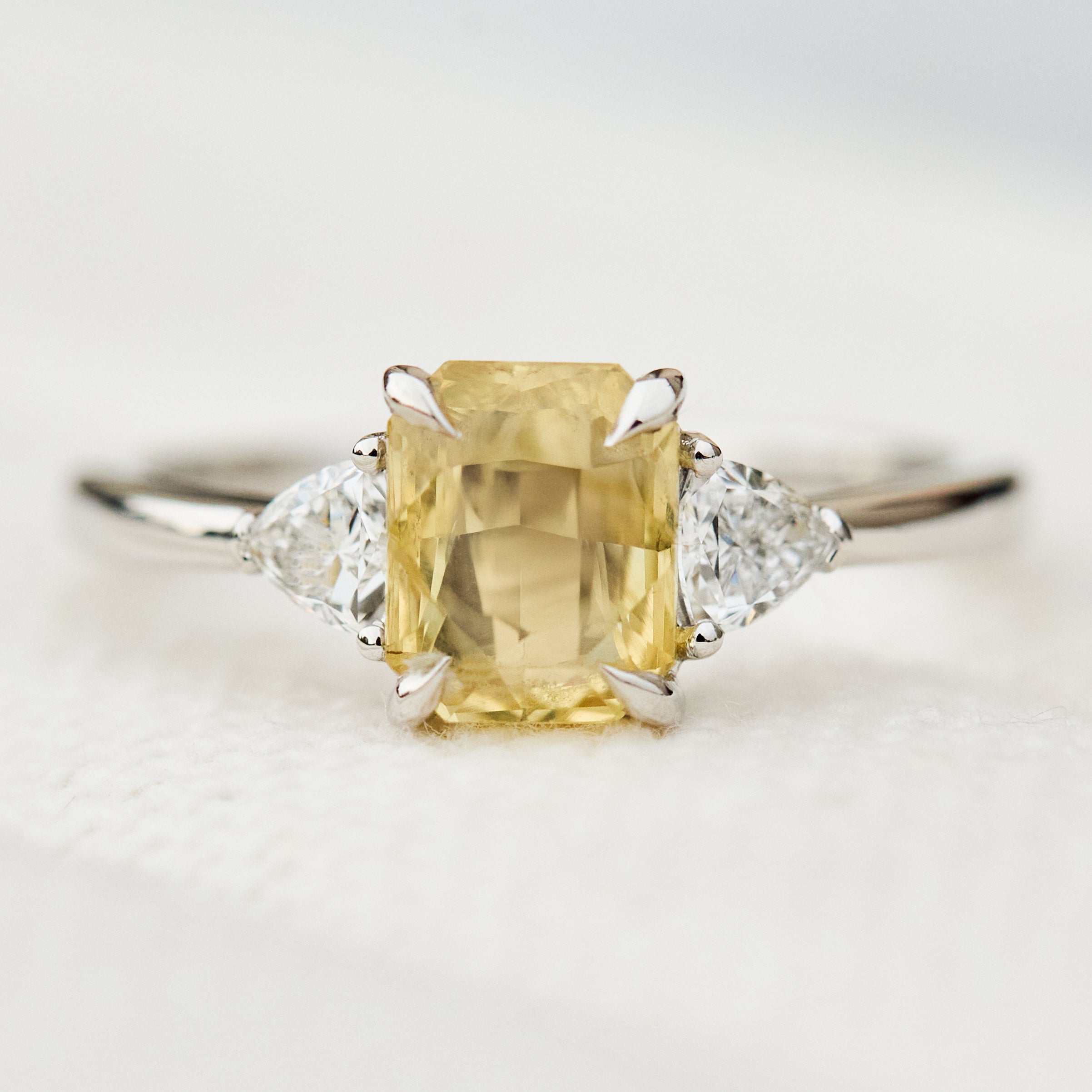 cushion cut yellow sapphire platinum trilogy engagement ring