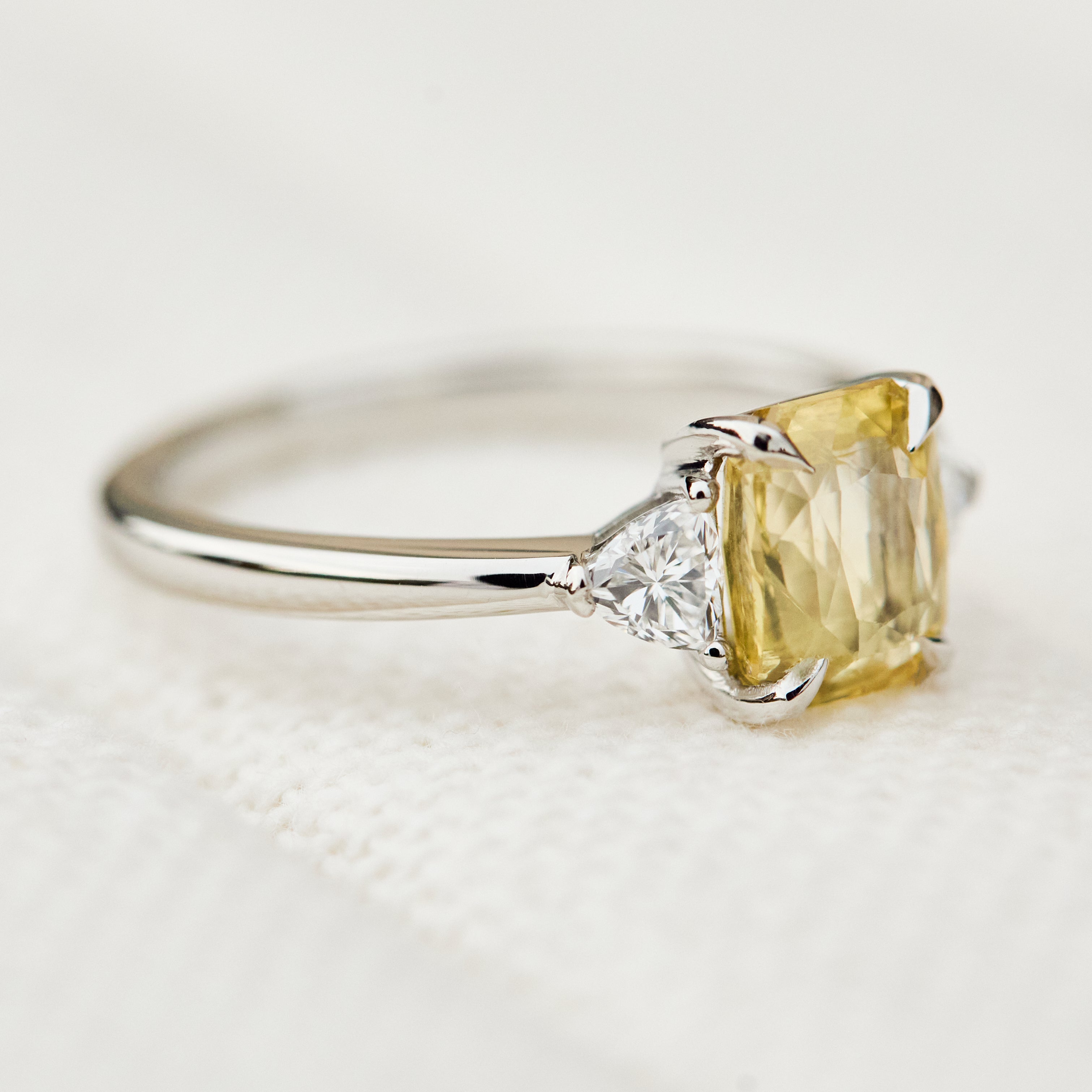 cushion cut yellow sapphire platinum trilogy engagement ring