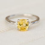 cushion cut yellow sapphire trilogy engagement ring in platinum