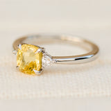 cushion cut yellow sapphire trilogy engagement ring in platinum