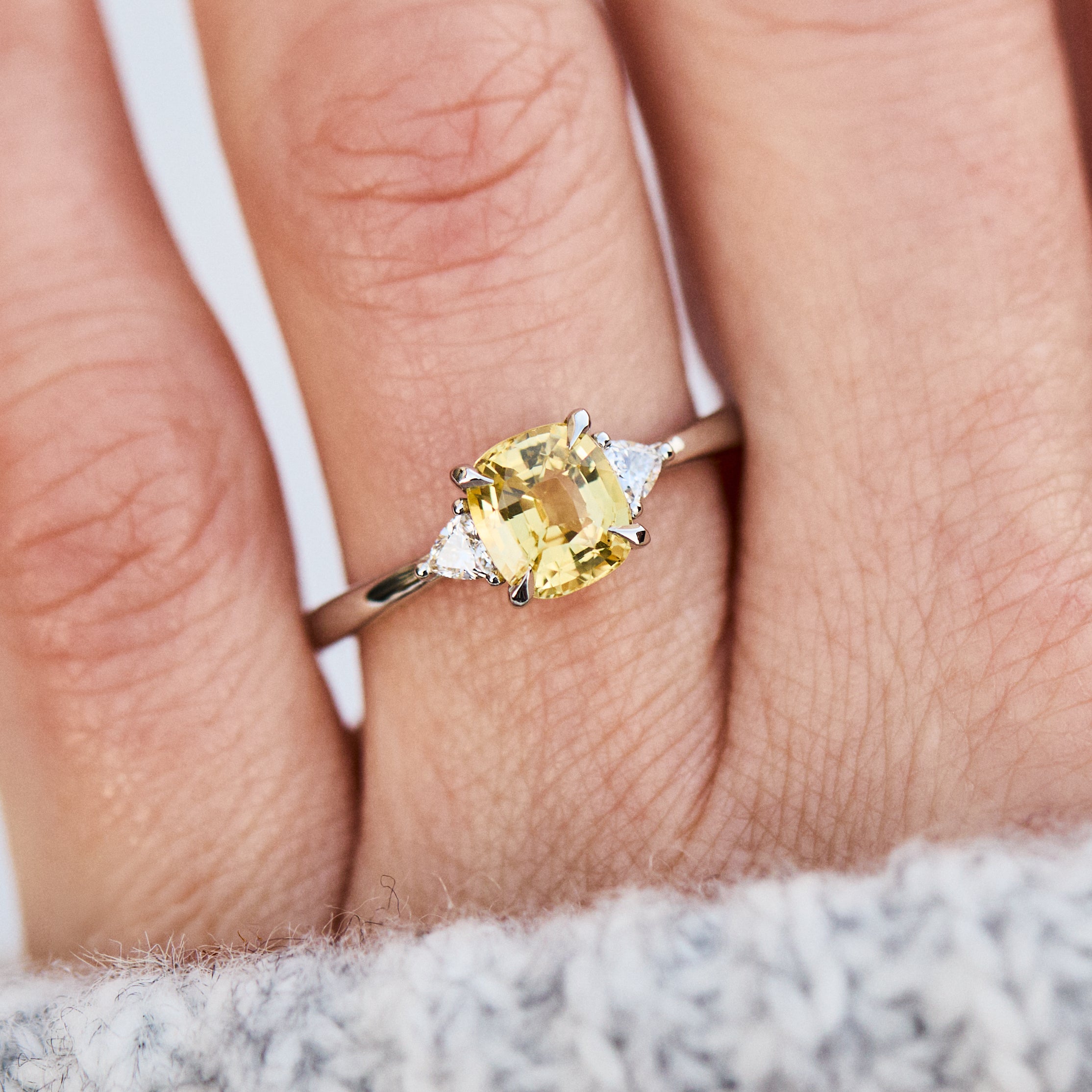 cushion cut yellow sapphire trilogy engagement ring in platinum