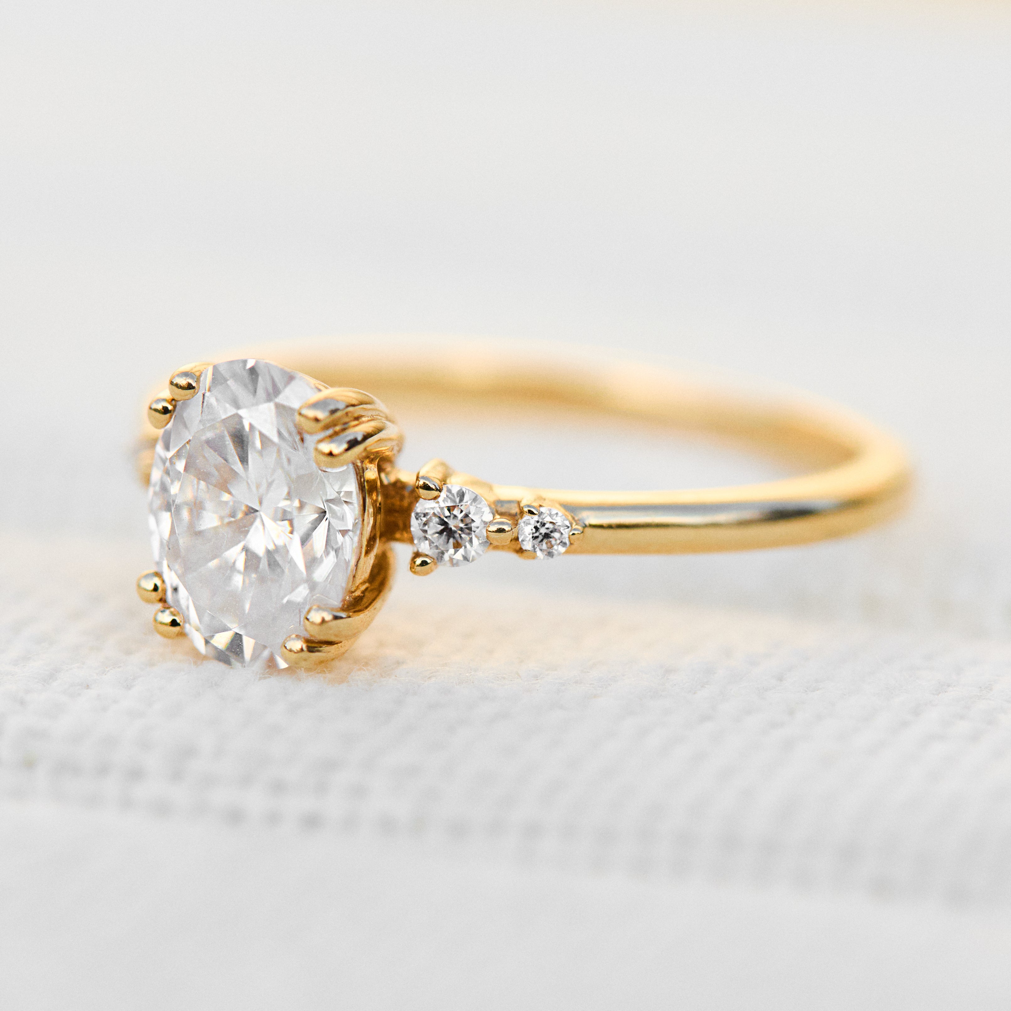 cushion cut moissanite and diamond engagement ring in yellow gold