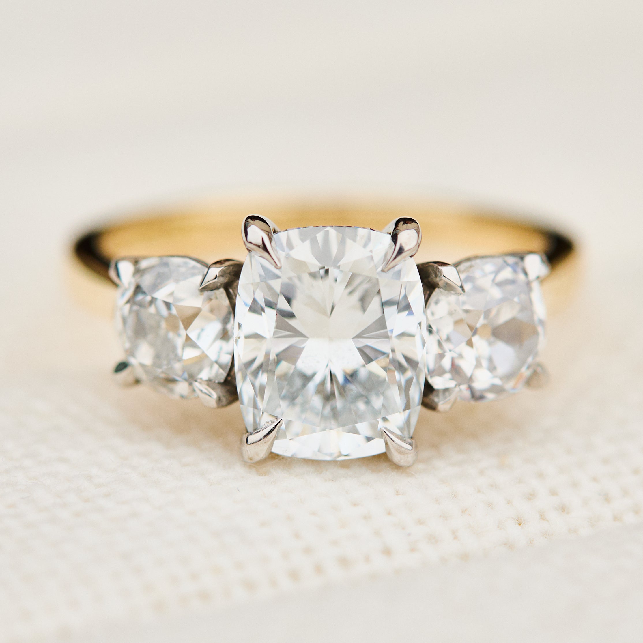 elongated cushion lab grown diamond trilogy engagement ring in yellow gold