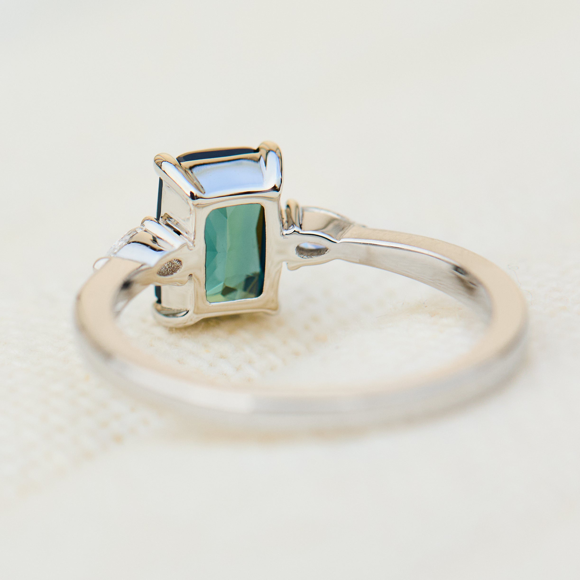 emerald cut blue teal sapphire trilogy engagement ring in platinum