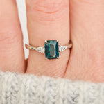 emerald cut blue teal sapphire trilogy engagement ring in platinum
