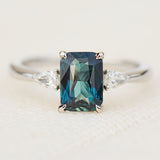 emerald cut blue teal sapphire trilogy engagement ring in platinum