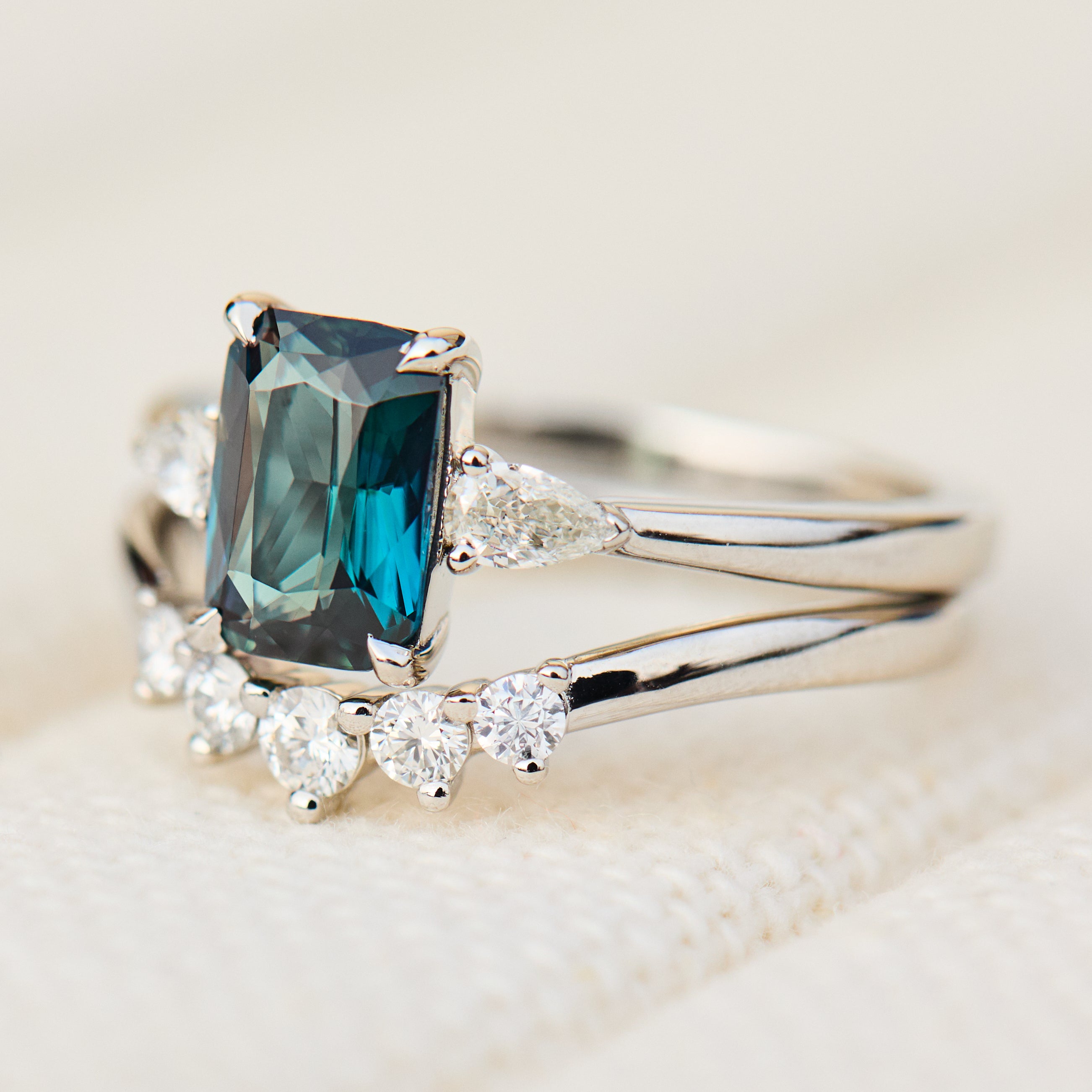 emerald cut blue teal sapphire trilogy engagement ring in platinum