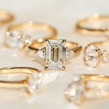 emerald cut lab grown diamond trilogy engagement ring set in yellow gold