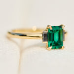 emerald cut emerald trilogy engagement ring set in yellow gold