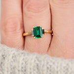 emerald cut emerald trilogy engagement ring set in yellow gold