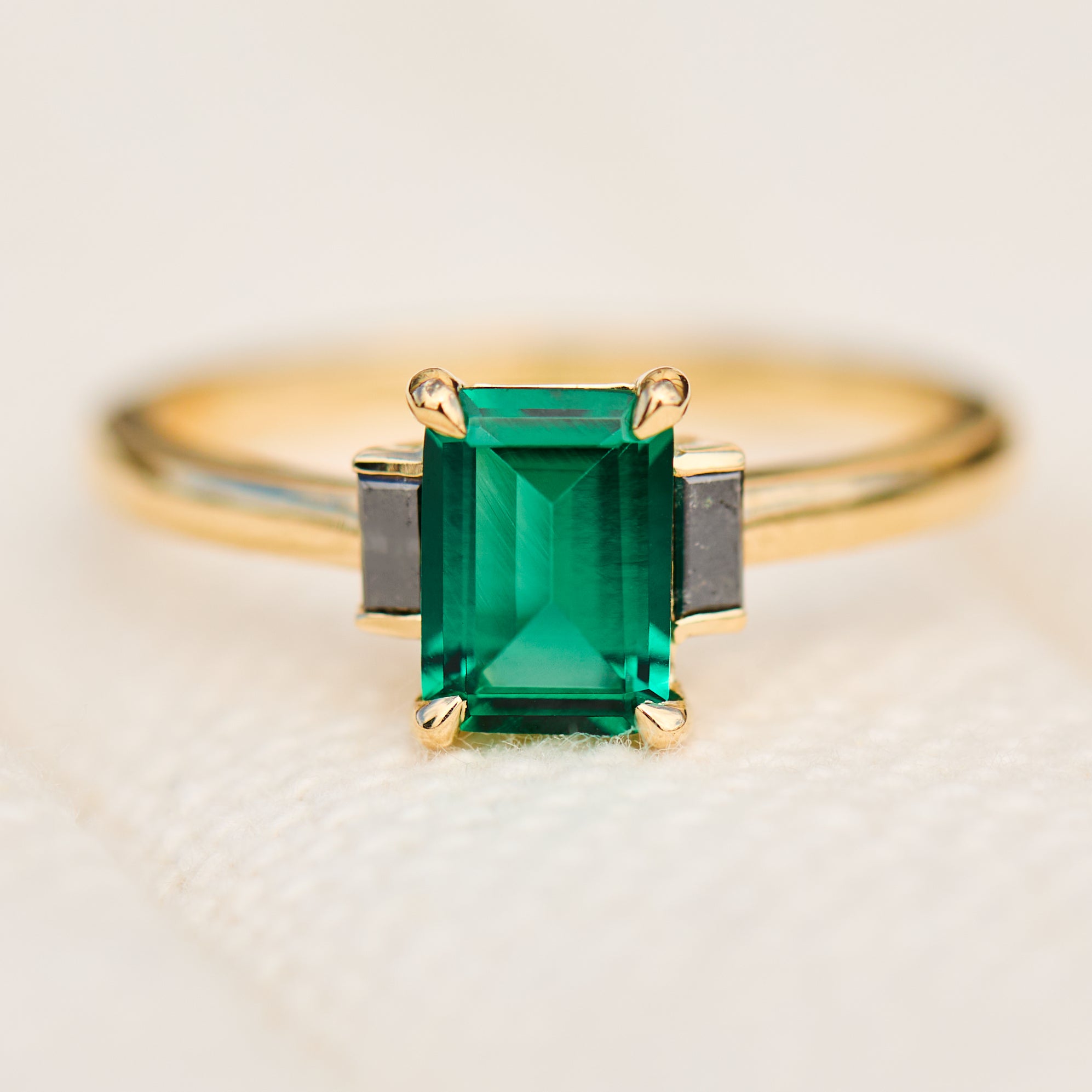 emerald cut emerald trilogy engagement ring set in yellow gold