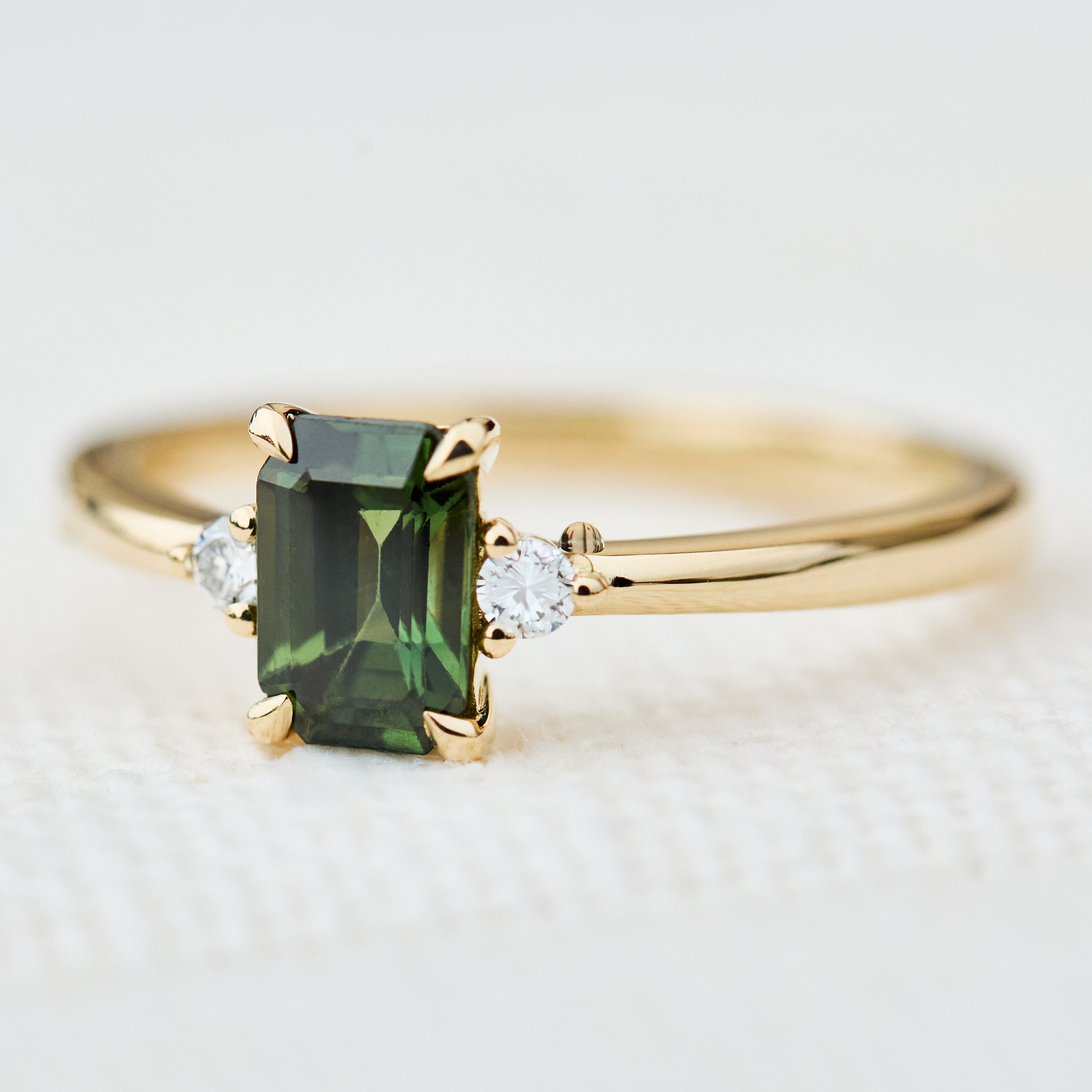 emerald cut green sapphire ring in yellow gold