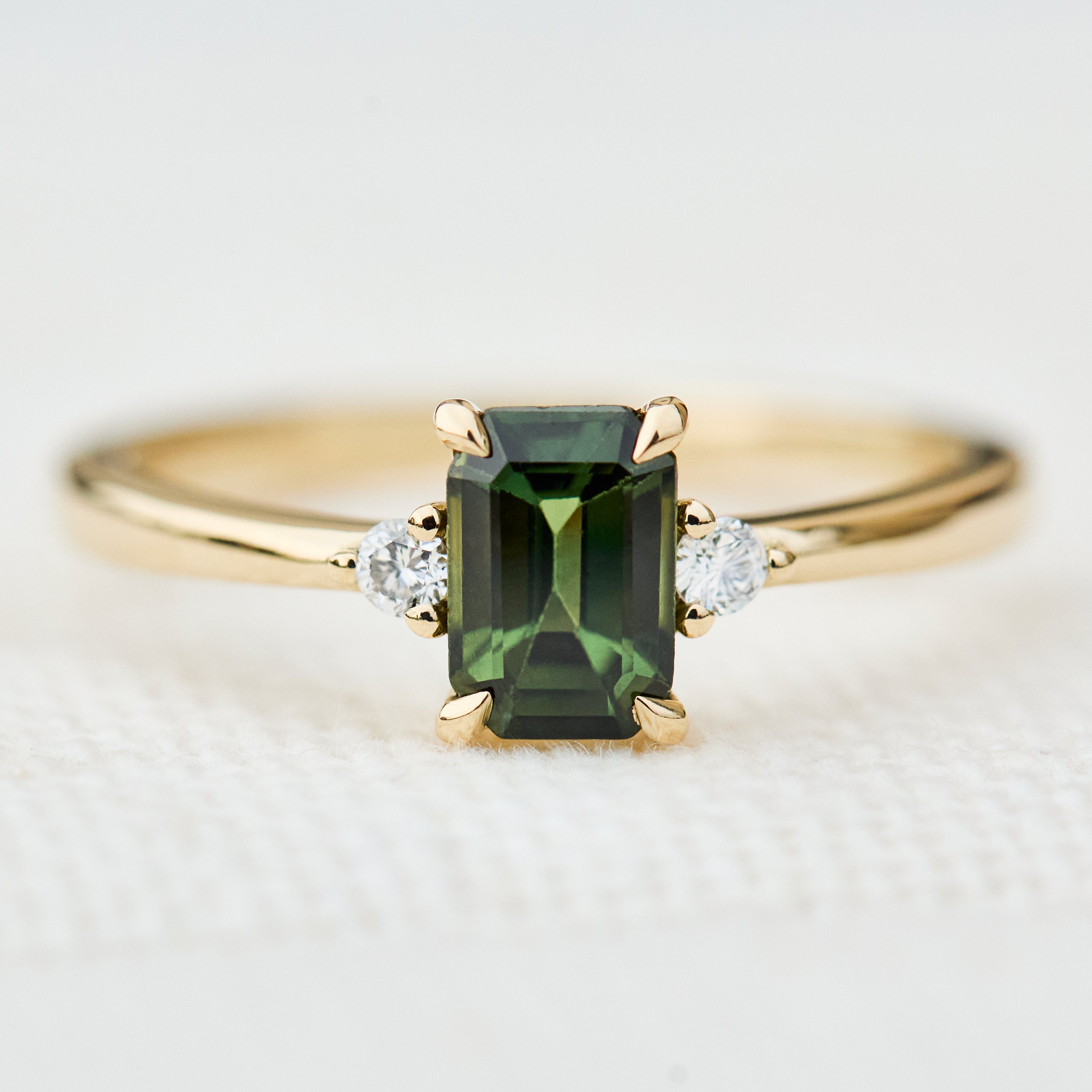 emerald cut green sapphire ring in yellow gold