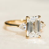 emerald cut lab grown diamond trilogy engagement ring set in yellow gold