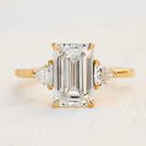 emerald cut lab grown diamond trilogy engagement ring set in yellow gold