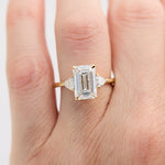 emerald cut lab grown diamond trilogy engagement ring set in yellow gold
