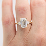 emerald cut lab grown diamond trilogy engagement ring set in yellow gold