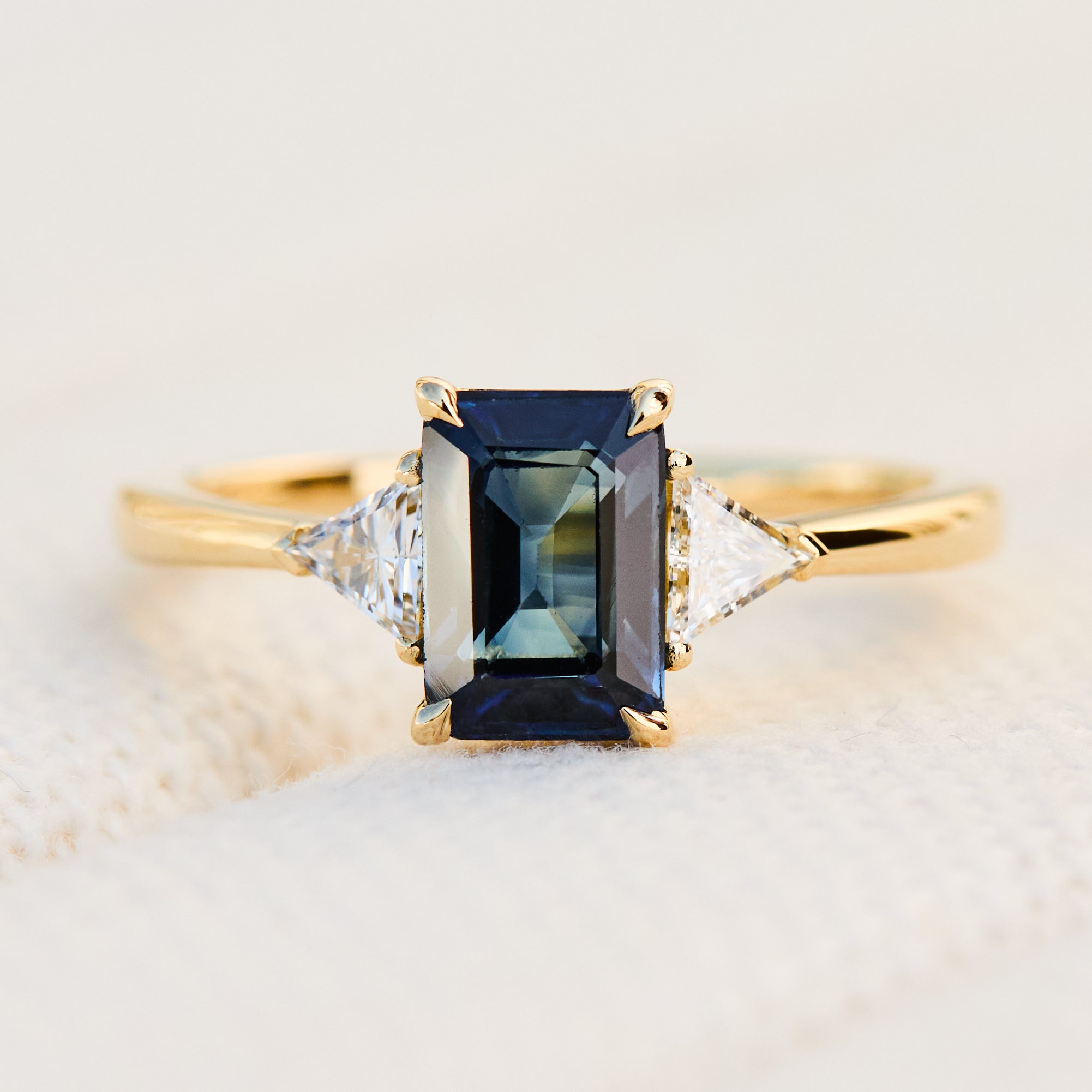 emerald cut sapphire trilogy engagement ring in yellow gold