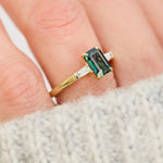 emerald cut teal sapphire trilogy engagement ring in yellow gold